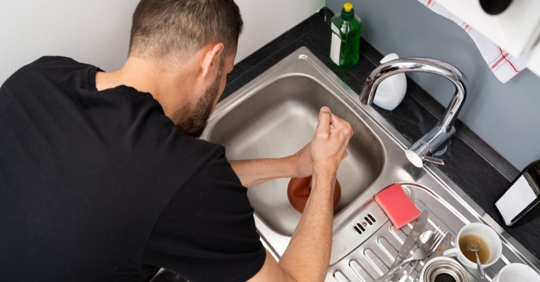 A homeowner trying to unclog their sink.